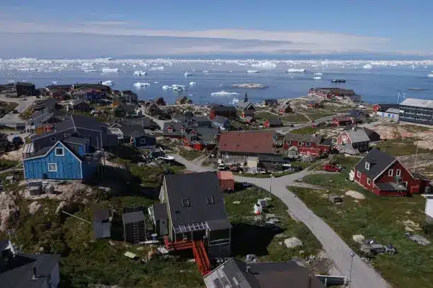 ilulissat greenland houses stand as icebergs drift by in disko bay on july 15 2024 in