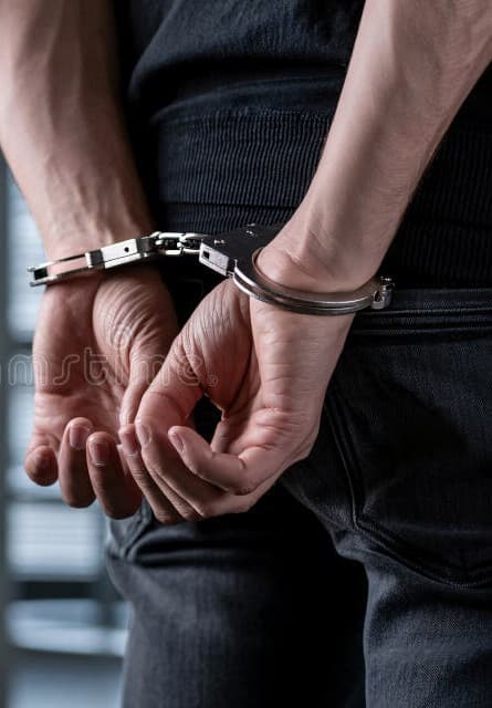 hombre-con-las-esposas-en-la-espalda-vista-trasera-de-un-armario-una-persona-ropa-oscura-y-manos-esposadas-detrás-metálicas-son-411249122 (1)